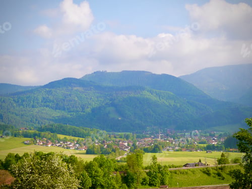 Preview: Alpine Tranquility: A Charming Small Town Nestled Beneath the Green Majesty of the Alps