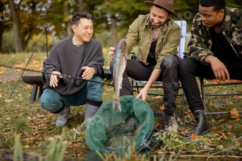 Preview: Male friends look catch in fishing net at fishing