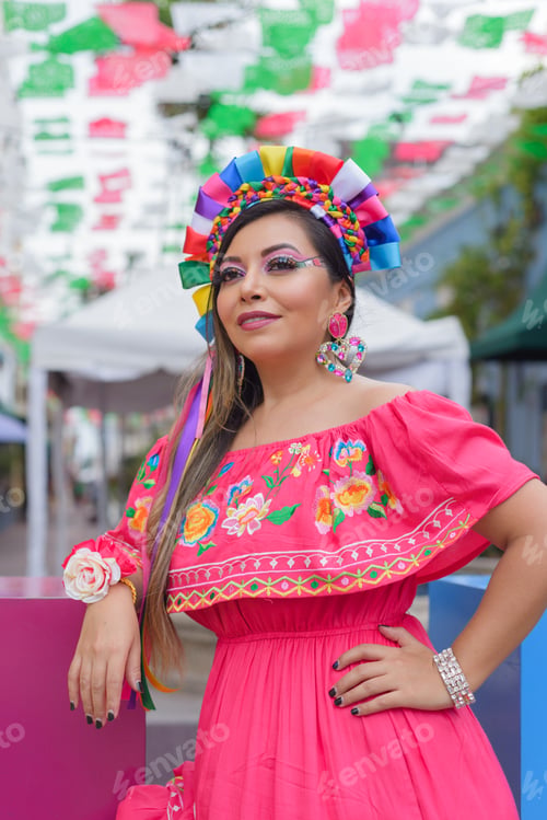 Preview: Mexican woman wearing traditional dress with multicolored embroidery celebrating independence day.
