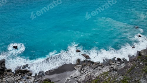 Preview: Stunning Taiwan coastline with clear turquoise waters and a rocky shore in bright sunlight