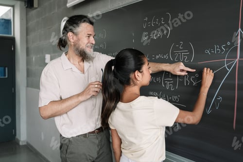 Preview: Latin Female Teenager Student doing Maths Exercises on Blackboard with help of friendly professor