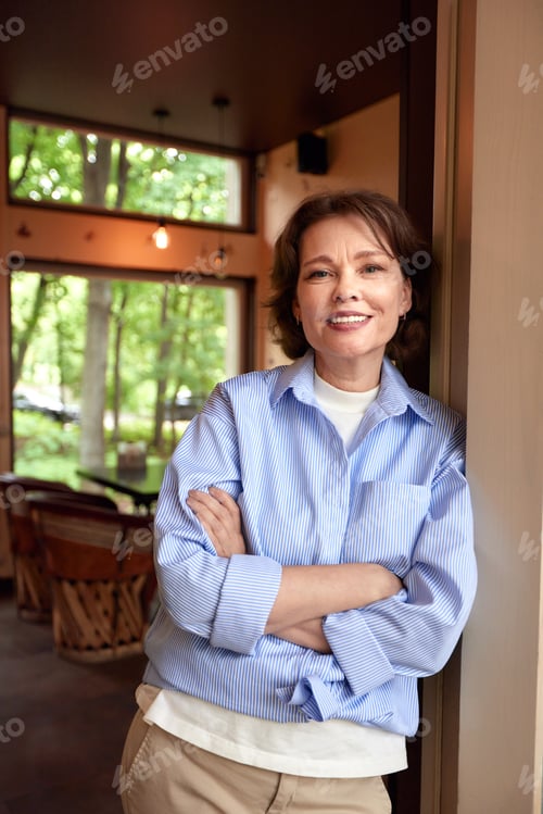 Preview: Portrait of an attractive smiling elderly woman. Mature caucasian woman with crossed hands. Middle