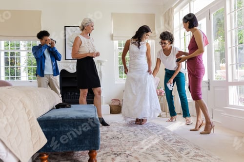 Preview: Bride in white dress surrounded by friends, preparing for wedding ceremony at home