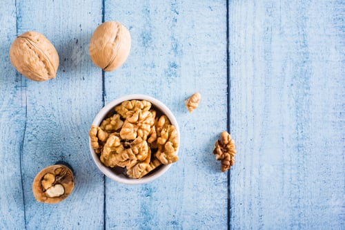 Preview: Peeled walnuts in a bowl on the table. Organic food. Top view