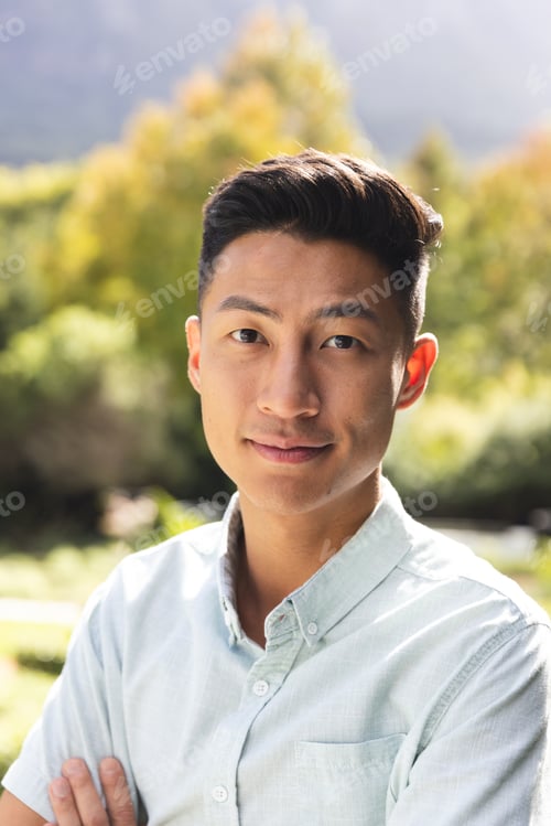 Preview: Portrait of happy asian man smiling in sunny garden