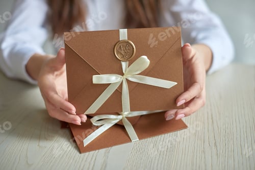 Preview: Gift Certificate, gift voucher or discount. close-up photo of invitation envelope with ribbon
