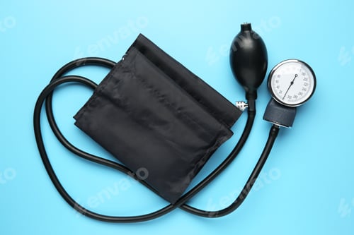 Preview: Blood pressure measuring device on light blue background, top view