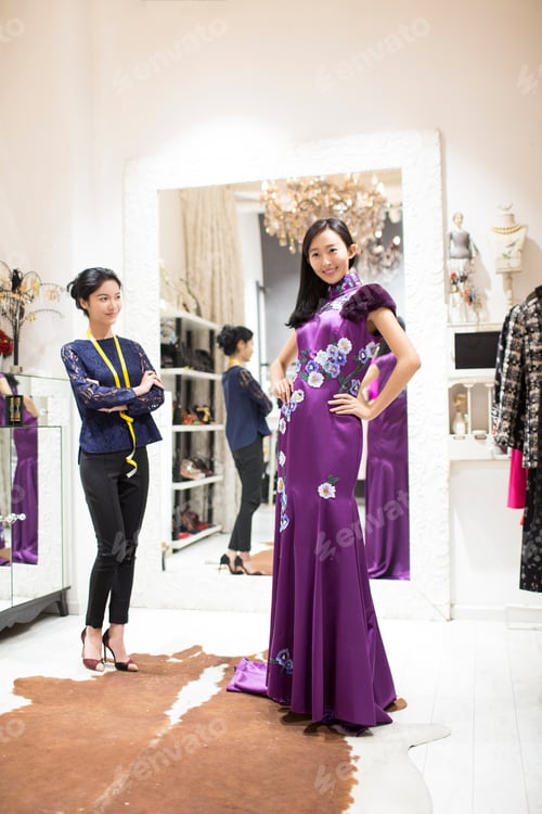 Preview: Fashion designer examining dress on customer