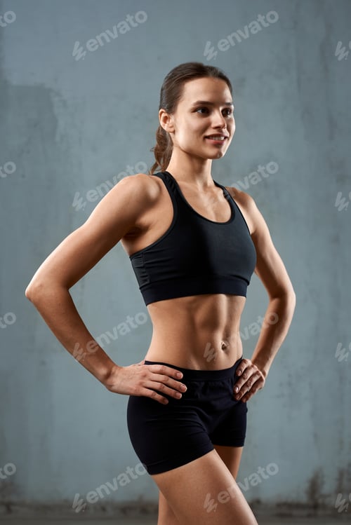 Preview: Sportswoman posing in sportswear, isolated on gray