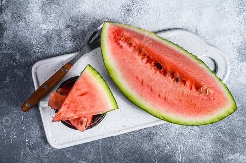 Preview: Slices of ripe watermelon on a white cutting Board. Gray background. Space for text