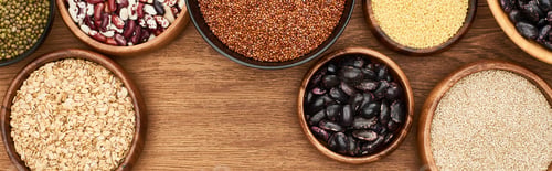 Preview: panoramic shot of bowls with oatmeal, buckwheat, beans and couscous on wooden surface