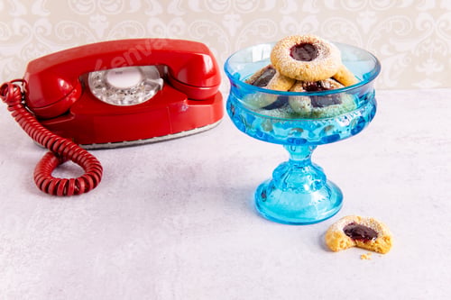 Preview: Old rotary phone with a vintage dish holding thumbprint cookies