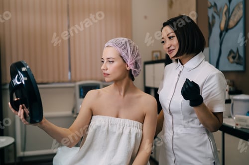 Preview: Women looking at mirror after botox injection