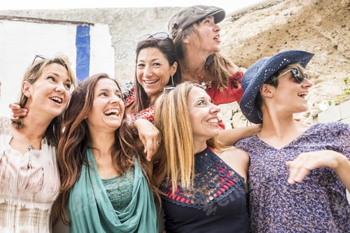 Preview: Group of cheerful happy young caucasian women hug and enjoy the outdoor leisure activity