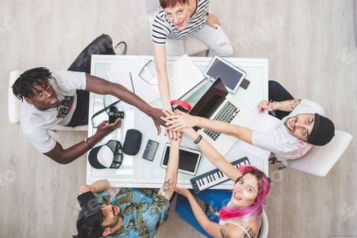 Preview: Team celebrates success with a highfive over a work table.