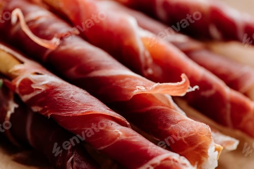 Preview: close up view of delicious sliced prosciutto wrapped around breadsticks