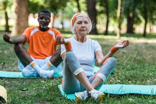 Preview: selective focus of retired senior woman and african american man with closed eyes sitting with
