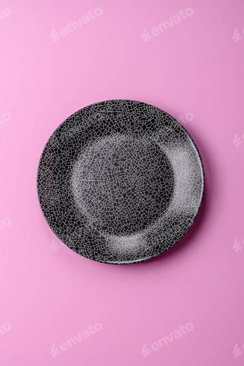 Preview: An empty round ceramic plate on a pink background as a kitchen utensil. An empty plate