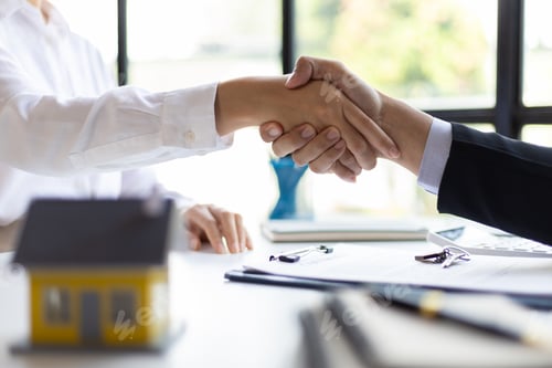 Preview: Businessman shaking hands with real estate agent in office after reaching home purchase agreement.