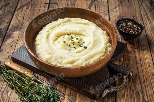 Preview: Mashed potatoes, boiled puree in a wooden plate. Wooden background. Top view
