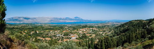 Preview: Ultra wide panormaic view of idyllic valley town with red roofs on mediterranean island. Olive