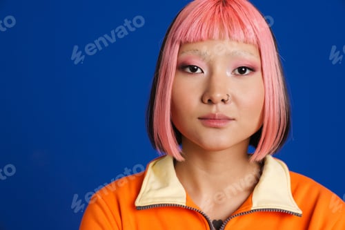 Preview: Asian girl with pink hair and piercing posing while looking at camera