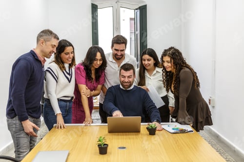 Preview: Group of coworkers collaborating in shared workspace with laptop