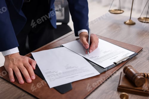 Preview: Notary signing document at wooden table in office, closeup