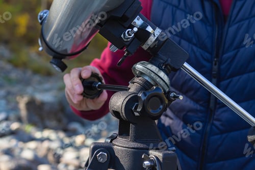 Preview: Close-up of digital scale and tilt lever of telescope with man's hand, selective focus, hobby