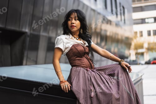 Preview: Closeup shot of a Southern Asian model in a vintage dress looking away and posing