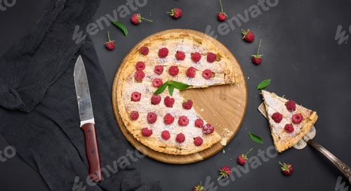 Preview: Round baked pie with apples and sprinkled with powdered sugar on a black table.