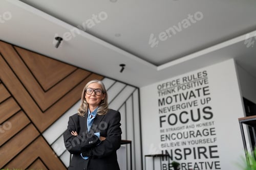 Preview: woman head of a company in business clothes stands in the middle of a modern office