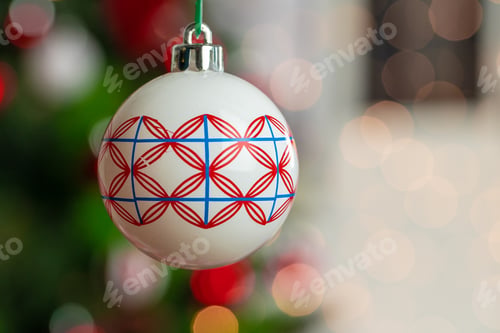 Preview: Red and white bauble hanging from a Christmas tree