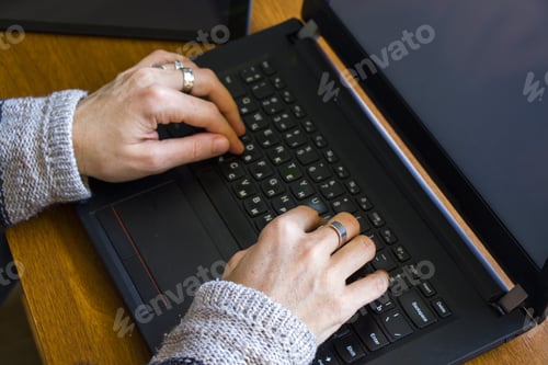Preview: Female typing on a laptop, working in an office