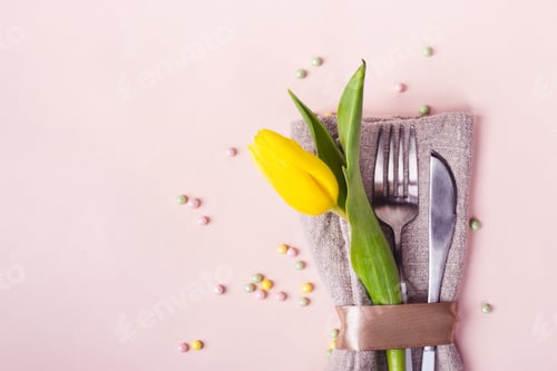 Preview: Spring Easter table setting. Cutlery is decorated with beautiful yellow tulip close-up
