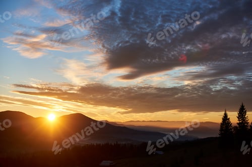 Preview: Sun rises behind hills, casting golden glow across sky filled with dramatic clouds.