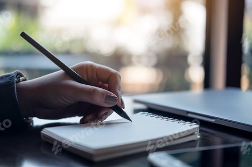 Preview: a woman's hands writing on notebook on the table