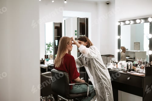 Preview: process of face makeup brush alignment of the face tone on a beautiful young woman model blonde