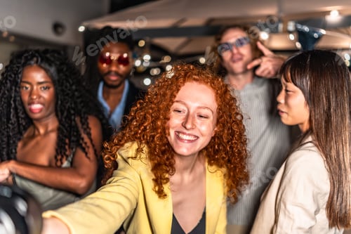 Preview: Happy friends taking selfie in a terrace during night party