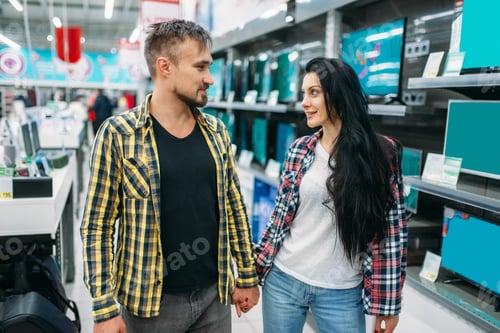 Preview: Young couple choosing electric iron in supermarket