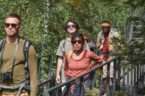 Preview: Hikers crossing forest bridge