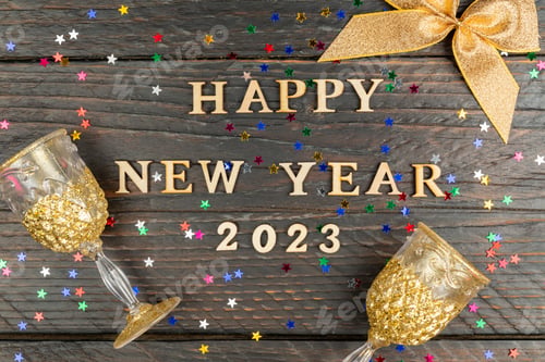 Preview: Happy new year 2023 on vintage style wooden texture background with champagne glasses