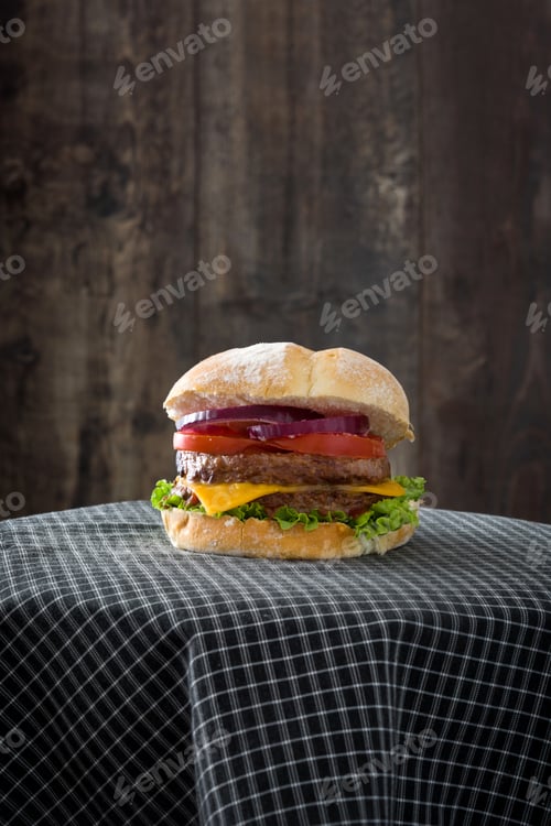 Preview: Delicious double burger resting on checkered tablecloth with rustic wooden background