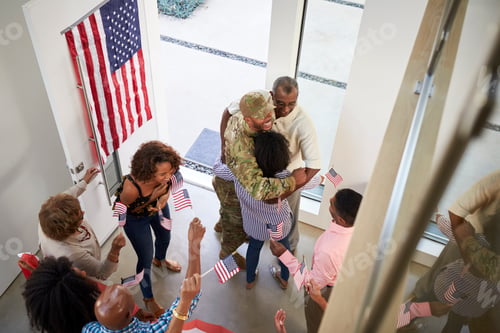 Preview: Young black male soldier welcomed home by three generation family, elevated view