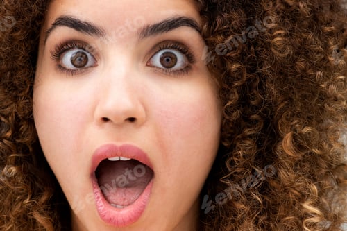 Preview: Close up surprised young woman with curly hair and mouth open