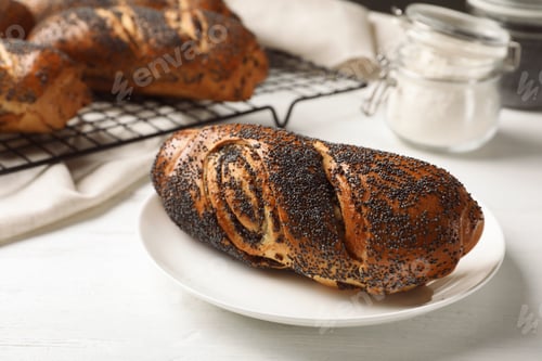 Preview: Plate with freshly baked poppy seed roll on table