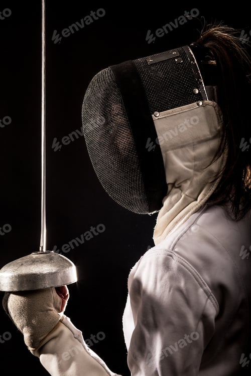 Preview: Portrait of woman wearing white fencing costume practicing with the sword.