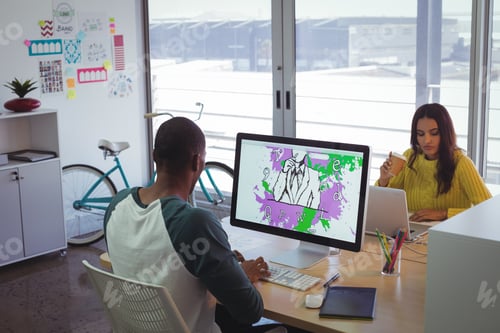 Preview: Graphic designers using computer and laptop in creative office