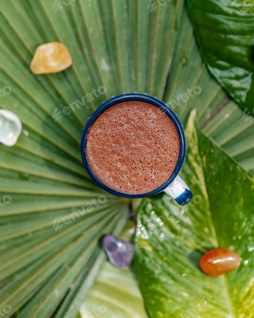 Preview: Cup of cocoa in Mexico on leaves surrounded by colorful crystals
