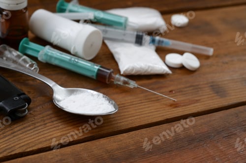 Preview: A lot of narcotic substances and devices for the preparation of drugs lie on an old wooden table
